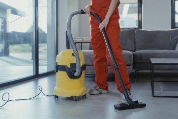 The powerful cleaning action of a Sparkle Window team member vacuuming a Brisbane living room floor.